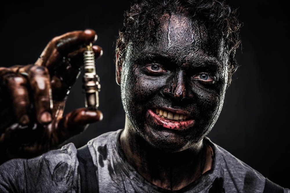 Mitarbeiterfoto Autohaus Gell, Mechaniker mit schwarzer Farbe im Gesicht