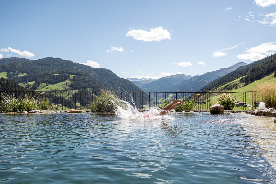 Gäste genießen den Schwimmteich im Bergengut Großarl – Lifestylefotografie von Hotelfotograf Lorenz Masser.