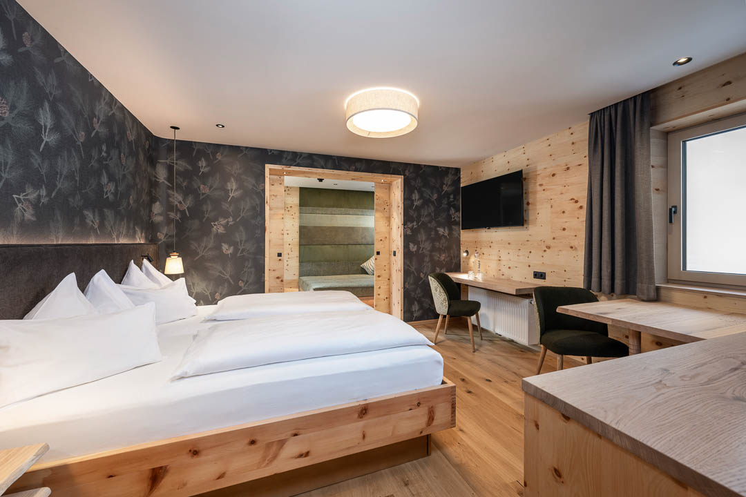 Modernes Hotelzimmer im Tirolerhof Flachau mit viel Holz und warmen Stoffen – fotografiert vom Fotograf Flachau.